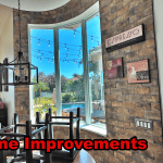 Premium custom impact windows installed in a curved radius stone wall overlooking the water