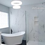 Luxury bathroom remodel on the Treasure Coast featuring a freestanding soaking tub, custom marble tile shower wall, and white double vanity.