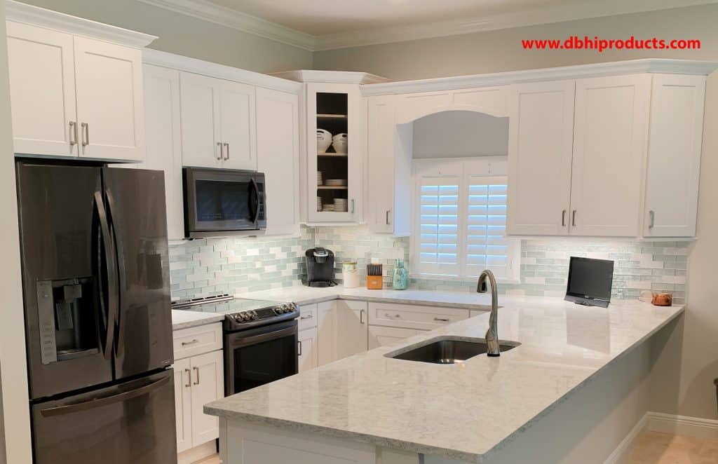 Open Concept White Quartz Kitchen Remodel Custom white shaker kitchen transformation featuring a peninsula breakfast bar, seamless quartz countertops, and updated appliance layout in Port St. Lucie, Florida.