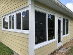 Precise corner installation of PGT impact windows integrated with James Hardie lap siding and custom white PVC trim