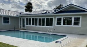 Home exterior remodel featuring impact windows, new siding, porch conversion and backyard pool layout